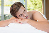 Man lying on massage table at spa center