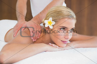 Woman receiving shoulder massage at spa center
