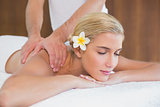 Woman receiving shoulder massage at spa center