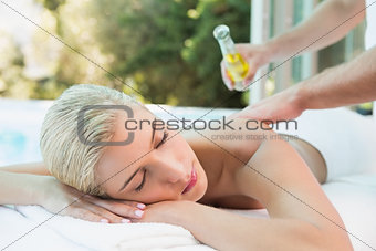 Woman receiving back massage at spa center