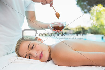 Woman receiving spa treatment with honey
