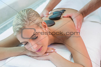 Beautiful woman receiving stone massage at health farm