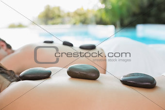 Mid section of a couple enjoying stone massage