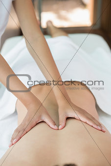 Man receiving back massage at spa center