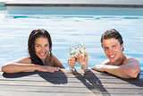 Couple toasting champagne in swimming pool