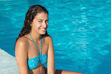 Beautiful young woman by swimming pool