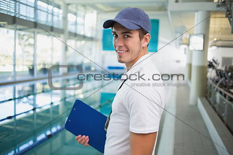Swimming instructor smiling at camera by the pool