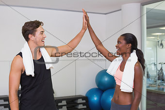 Personal trainer and client high fiving