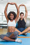 Fit couple warming up on exercise mats
