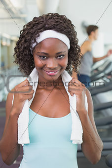 Pretty woman smiling at camera beside treadmills