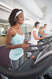 Fit woman on treadmill listening to music