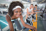 Three fit people working out on exercise bikes