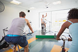 Spin class working out with motivational instructor