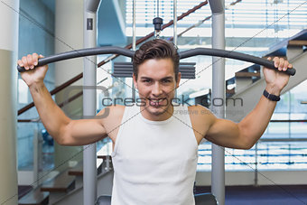 Strong man using weights machine for arms