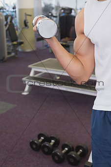 Fit man holding heavy dumbbell
