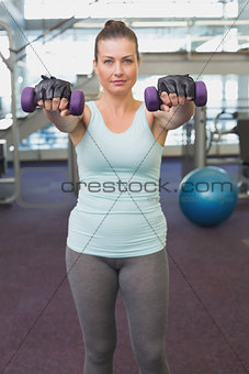 Fit brunette working out with dumbbells