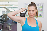 Fit brunette working out with kettlebell