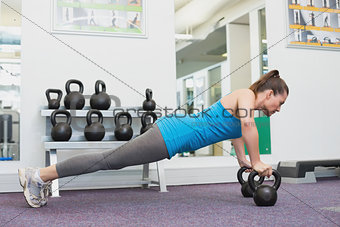 Fit brunette working out with kettlebell