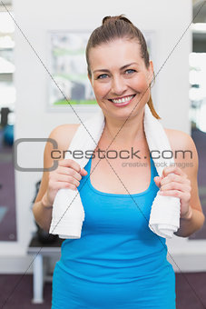 Fit brunette smiling at camera in fitness studio