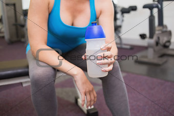 Fit brunette holding sports bottle