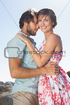 Gorgeous couple embracing by the coast