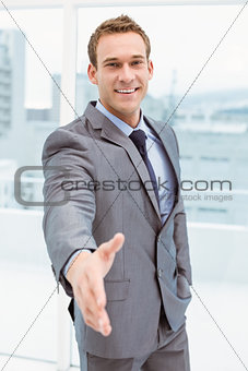 Portrait of smart businessman offering handshake