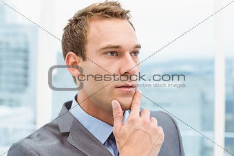 Thoughtful young businessman looking away