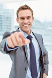 Smart young businessman in suit pointing at you