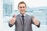 Businessman gesturing thumbs up in office