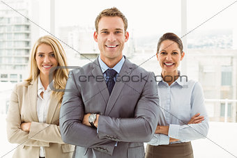 Young business people with arms crossed in office