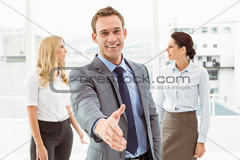 Businessman with colleagues behind at office