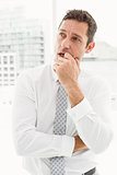 Thoughtful businessman looking away at office