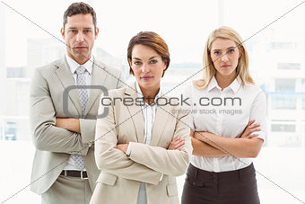 Confident business people with arms crossed in office