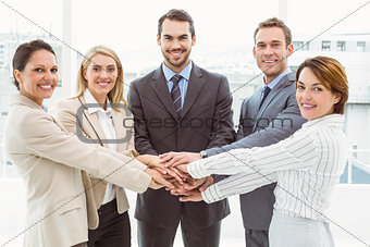 Happy executives holding hands together in office