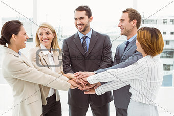 Executives holding hands together in office