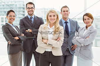 Young business people with arms crossed in office
