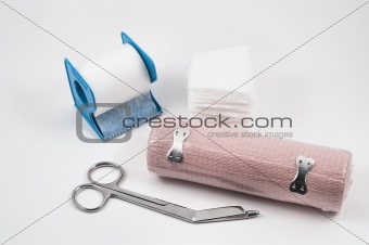 medical gauze, tape, bandage and scissors
