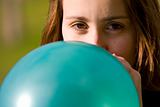 Woman inflating blue balloon