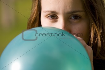 Woman inflating blue balloon