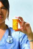 Nurse holding bottle of prescription pills