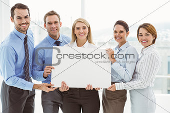 Young business people holding blank board in office