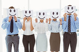 Business people holding happy smileys on faces