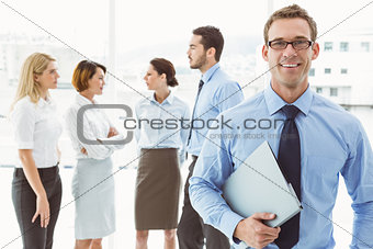 Smiling businessman with colleagues behind