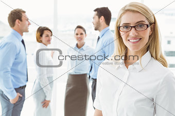 Businesswoman with colleagues behind at office