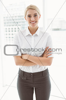 Beautiful businesswoman with arms crossed in office