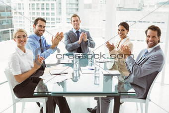Business people clapping hands in board room meeting