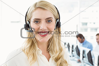 Smiling businesswoman with executives using computers
