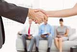 Handshake besides people waiting for interview