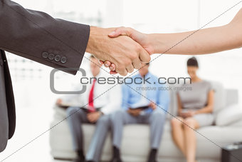 Handshake besides people waiting for interview