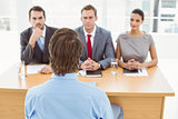 Business people interviewing man in office